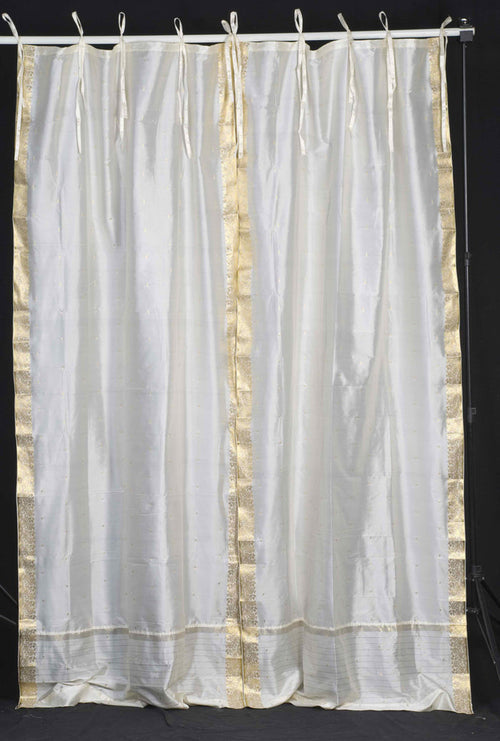 Cream sari tie top curtains hung at a window
