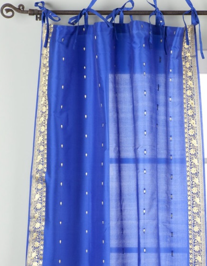 Blue sari tie top curtains hung at a window