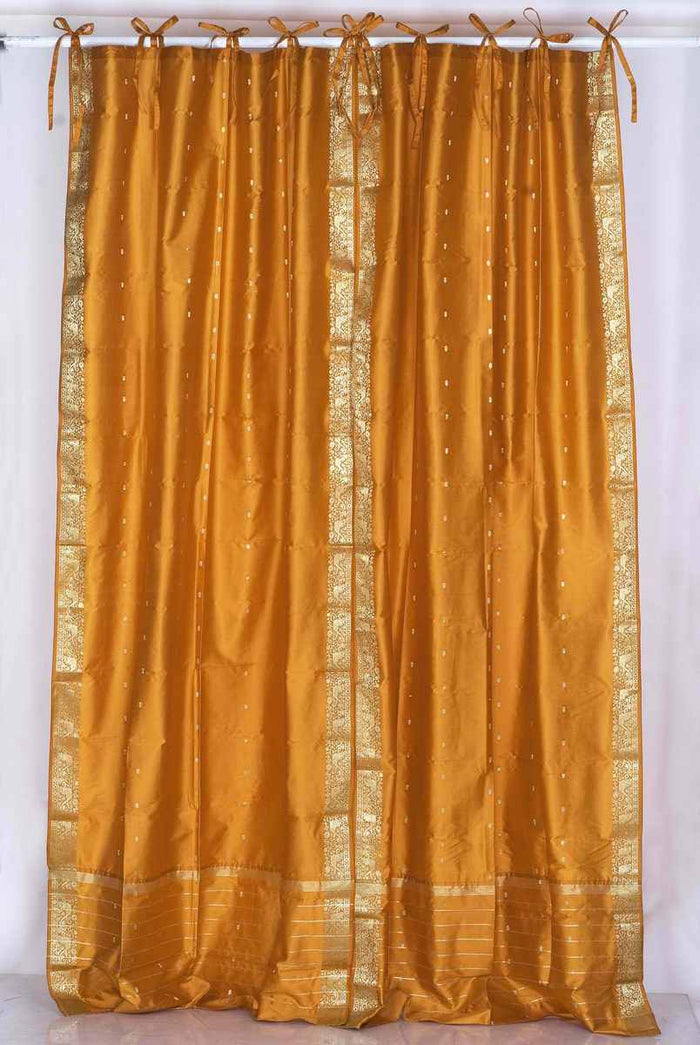 Mustard sari tie top curtains hung at a window