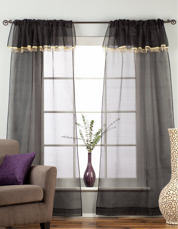 Black sheer tissue rod pocket curtains hung at a window