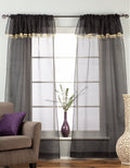 Black sheer tissue rod pocket curtains hung at a window