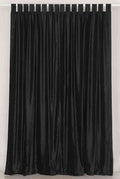Black velvet tab top curtains hung at a window