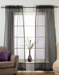 Black sheer tissue rod pocket curtains hung at a window