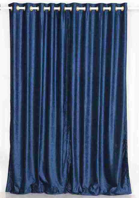 Navy blue velvet grommet top curtains hung at a window