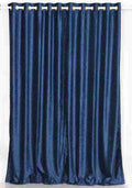 Navy blue velvet grommet top curtains hung at a window