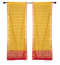 Yellow sari rod pocket curtains hung at a window