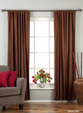 Brown velvet rod pocket curtains hung at a window