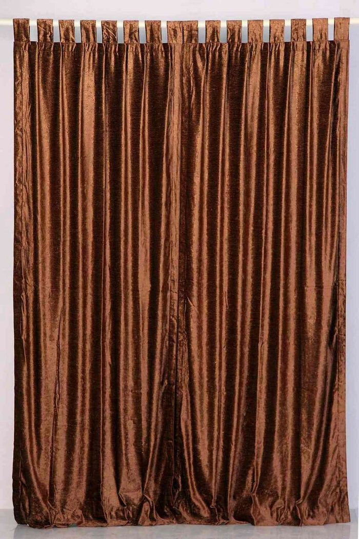 Brown velvet tab top curtains hung at a window