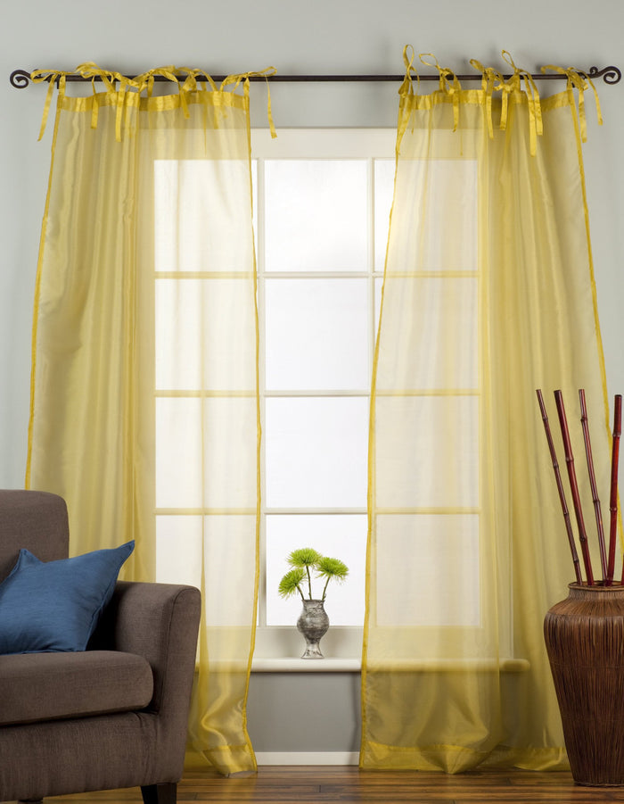 Gold sheer tissue tie top curtains hung at a window