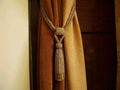 Golden sari curtain tiebacks holding a panel open