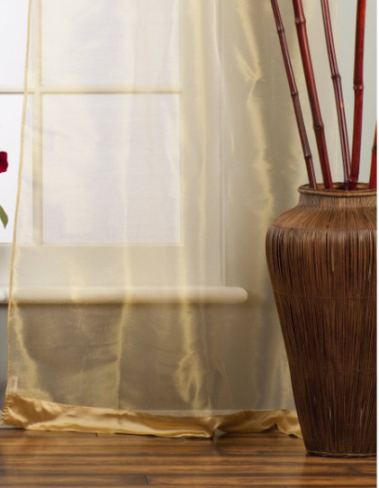 Golden sheer tissue tab top curtains hung at a window