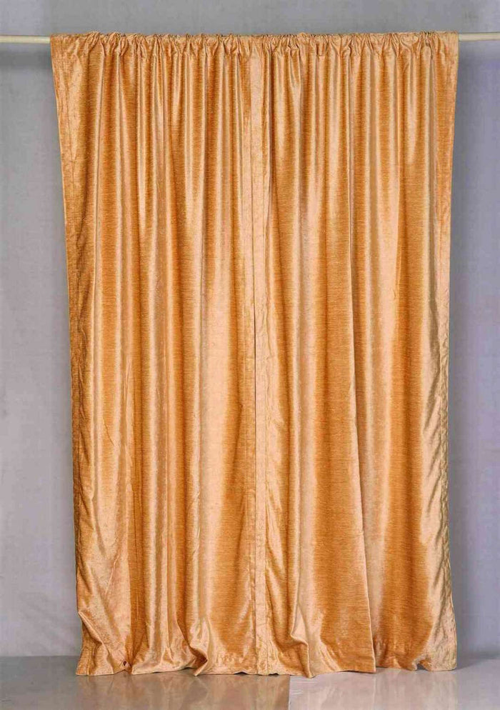Peach velvet rod pocket curtains hung at a window