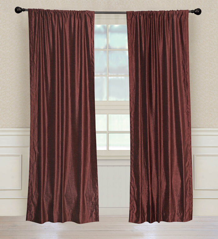 Wine velvet rod pocket curtains hung at a window