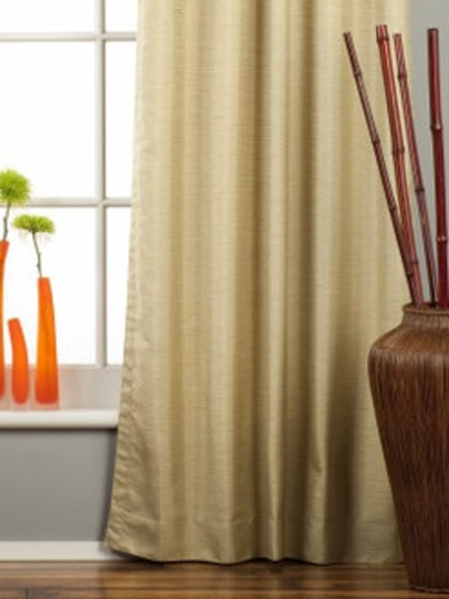 Olive green raw silk rod pocket curtains hung at a window