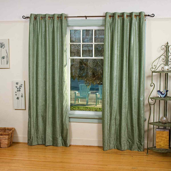 Olive green velvet grommet top curtains hung at a window