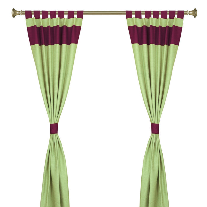 Olive green raw silk tab top curtains hung at a window