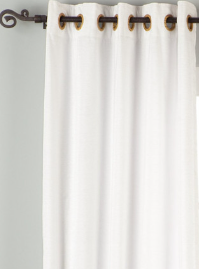 White velvet grommet top curtains hung at a window