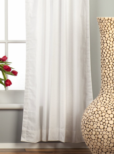 White velvet rod pocket curtains hung at a window