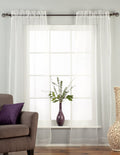 White sheer tissue rod pocket curtains hung at a window