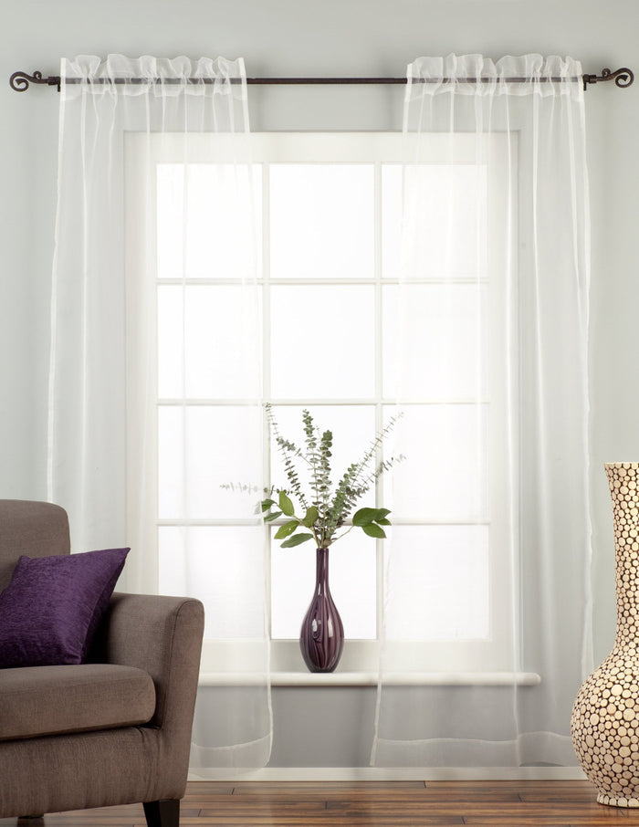 White sheer tissue rod pocket curtains hung at a window