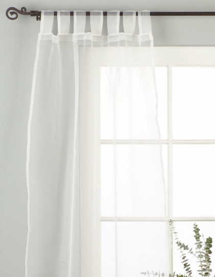 White sheer tissue tab top curtains hung at a window