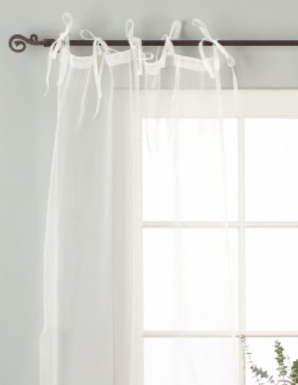 White sheer tissue tie top curtains hung at a window