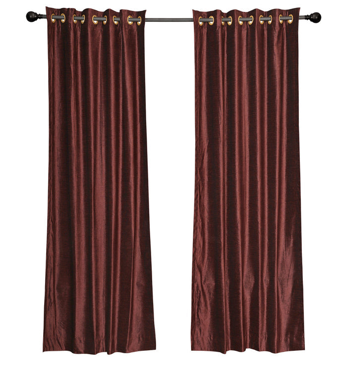 Wine velvet grommet top curtains hung at a window